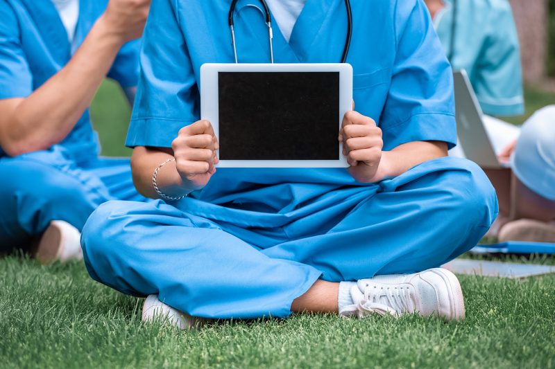 cropped image of medical student holding tablet with blank screen